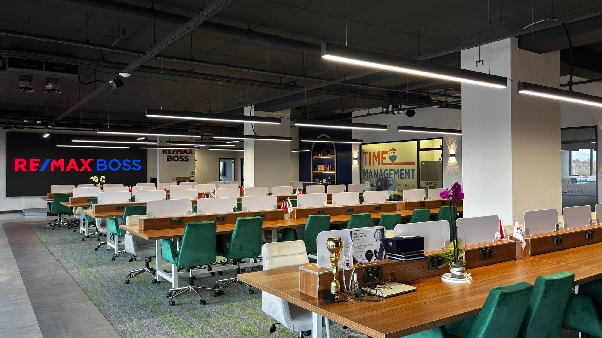 RE/MAX BOSS açık ofis — LED ekran ve çalışma masaları